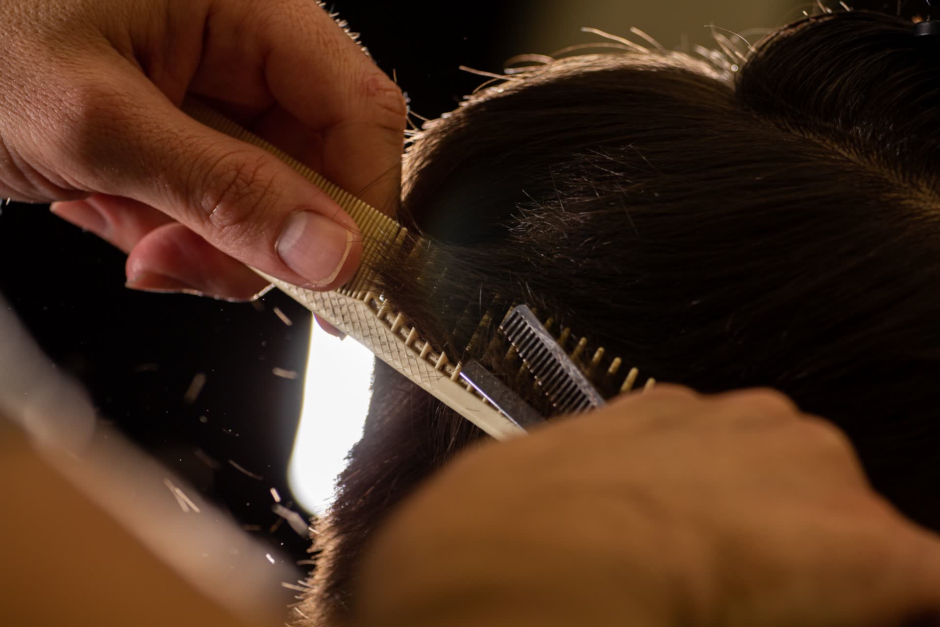 Roberto penteando o cabelo com pente de cabo e tesoura